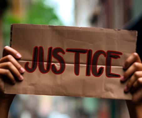 Black woman protesting in a big demonstration holding a blank pl